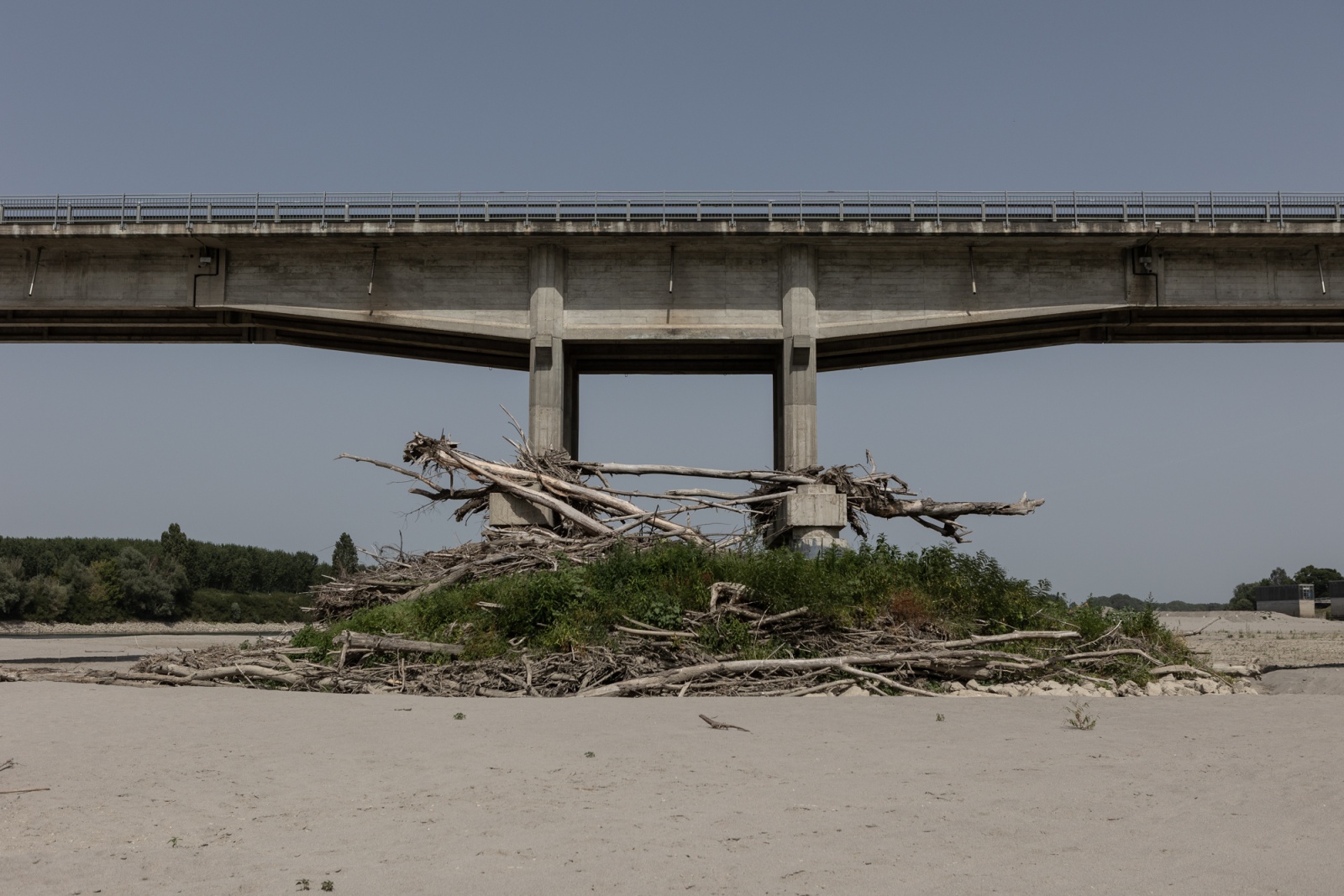 EMILIA ROMAGNA, ITALY - JUNE 2022 - One of the pylons of the bridge that crosses the river Po in the municipality of Boretto, in the province of Reggio Emilia, Italy on June 27, 2022. The branches and trees found meters from the river bed indicate the level that the river water normally reaches.
