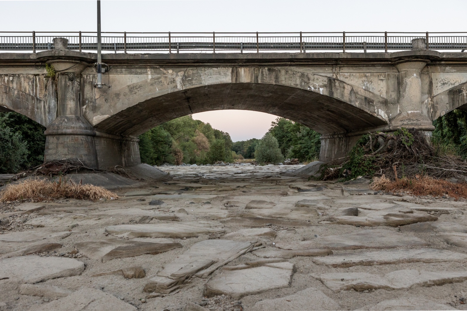 PIEDMONT, ITALY - JUNE 2022 - A photo shows the dry bed of the Sangone river and one of the bridges that cross it in the municipality of Beinasco, in the province of Turin, Italy on June 24, 2022.